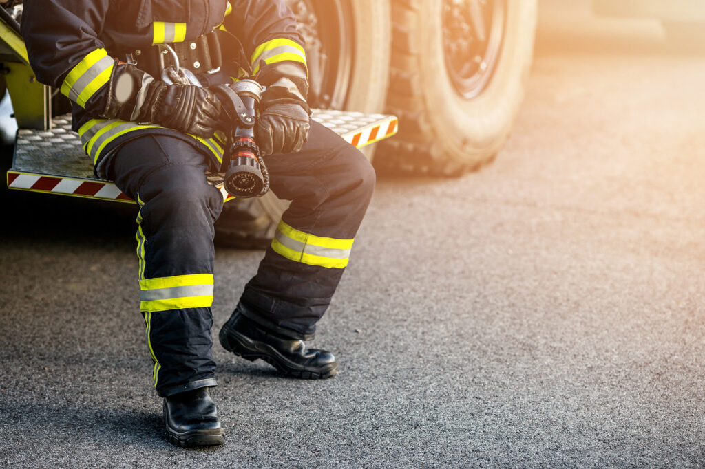 Firefighter in uniform near fire engine